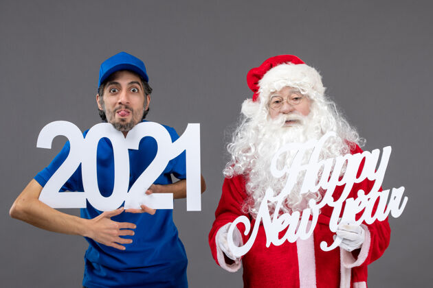 信使圣诞老人与男信使举行和新年快乐和2021年板灰墙的正面视图足球男人人