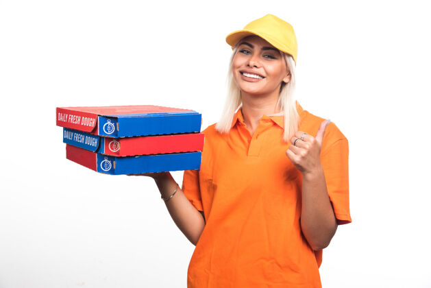 食物送比萨饼的女人拿着白色背景的比萨饼 手指指向一边高质量的照片人送货微笑