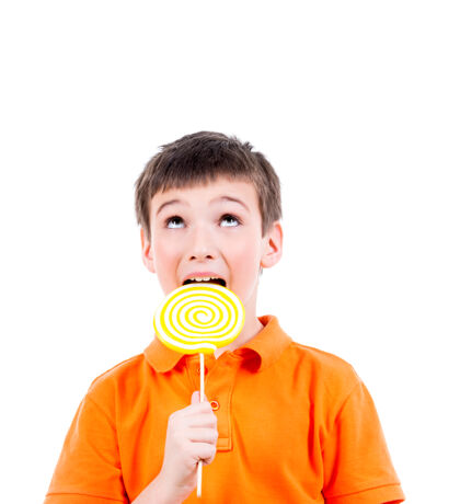 甜食穿着橙色t恤的快乐男孩正在吃彩色糖果-白色隔离糖果男性高兴