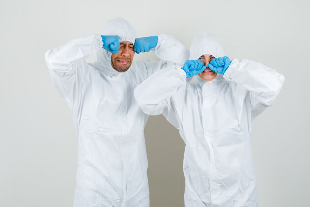人两个医生穿着防护服 戴着手套揉着眼睛 哭得像个孩子 看起来很害怕医生诊所医学