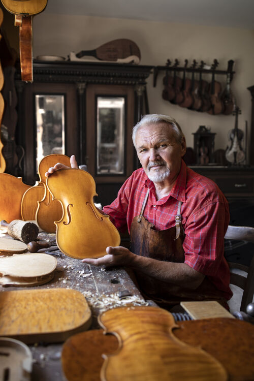 工艺高级木匠的画像 在他的旧时装作坊为艺术学院小提琴乐器锤子手持年份