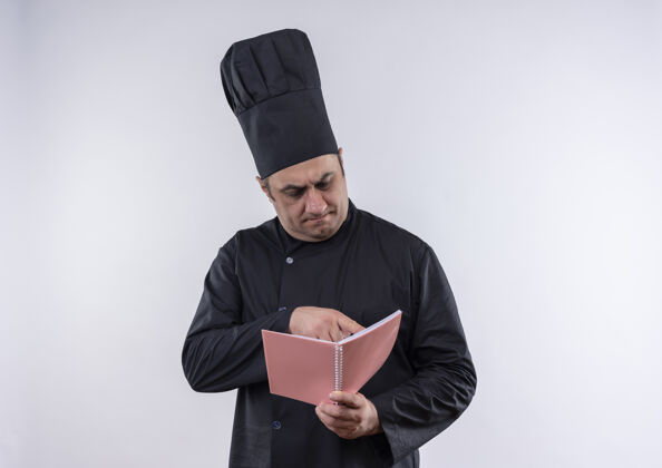 某物想着穿着厨师制服的中年男厨师在看手里笔记本上的东西厨师制服手