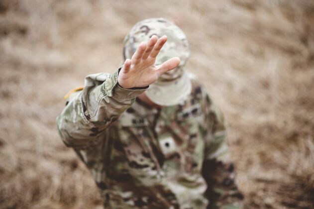 年轻人一个美国士兵举起手的选择性聚焦镜头祈祷保护者军队