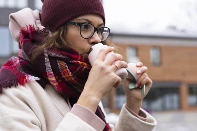 温暖特写镜头喝咖啡的女人冬天寒冷户外