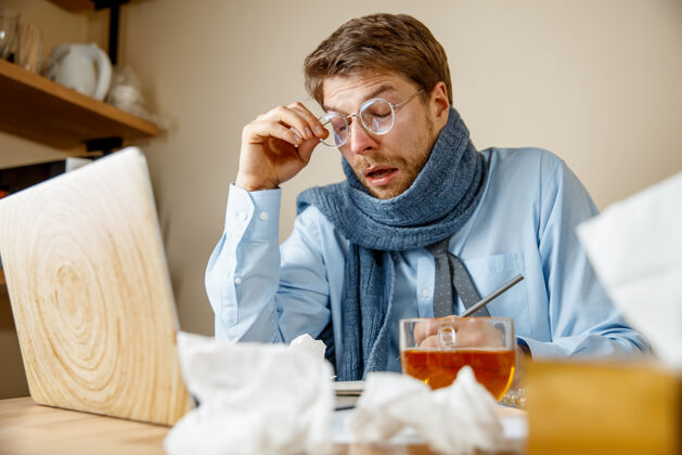 工人感到恶心和疲倦在办公室工作的人喝一杯热茶 商人感冒 季节性流感大流行性流感 疾病预防 办公室空调引起疾病就业过敏员工