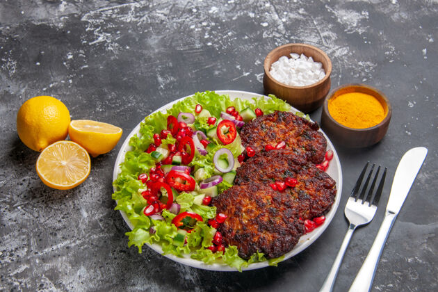 晚餐俯视图美味的肉排与沙拉和调味品的灰色背景照片美食菜肴一餐西红柿美味