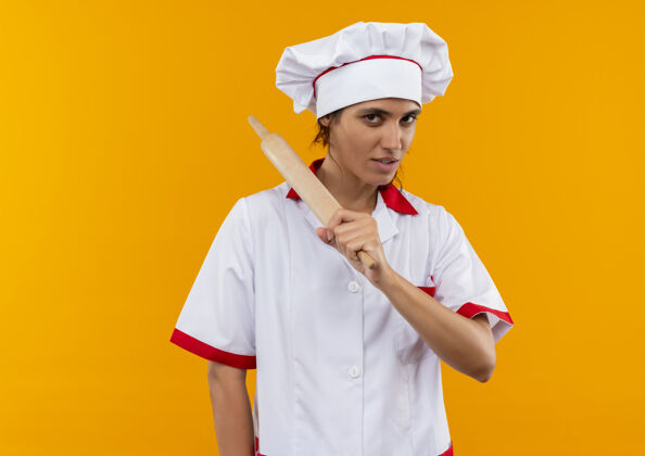穿高兴的年轻女厨师穿着厨师制服拿着擀面杖搂在肩上复制空间抱厨师厨师