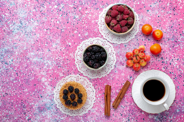 新鲜在粉红色的桌子上可以看到新鲜的野生浆果 覆盆子和黑莓 还有小蛋糕和茶关闭黑莓浆果
