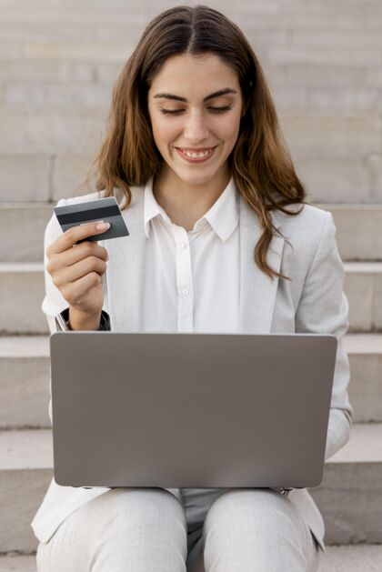 复杂笑脸女商人网上购物笔记本电脑和信用卡卡片个人优雅