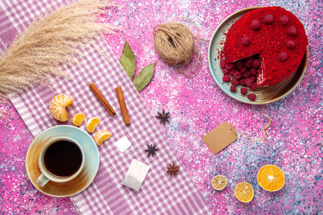 粉红色覆盆子蛋糕和肉桂橘子的俯视图 粉色表面上有一杯茶食品脸粉橘子
