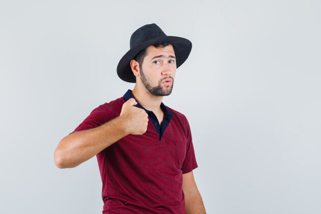自己穿着t恤的年轻男子 戴着帽子指着自己 看上去很不舒服 正对着前方看着自信严肃