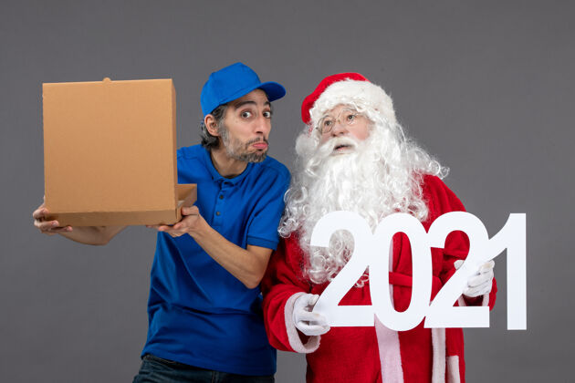 圣诞老人圣诞老人的正面图 男信使拿着食物盒 在灰色的墙上写字圣诞老人人男