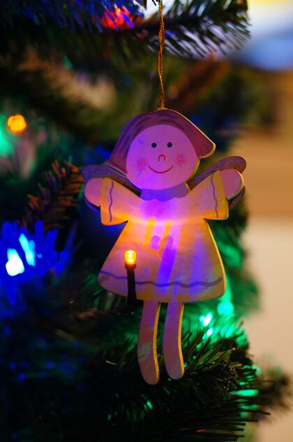 木头木制圣诞树天使装饰挂在树上点燃圣诞灯礼物年季节