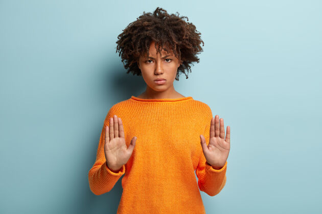 严重严肃的非裔美国女人的水平镜头显示停止手势 向相机伸手掌 禁止靠近 说够了卷发禁止警告