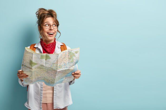 女性开朗的欧洲女人有有趣的旅行 看一边 拿着地图 查看路线或位置 在旅游城市旅行背包自由空间水平
