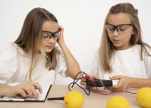 学习两个女孩用柠檬和电做科学实验安全实验教育