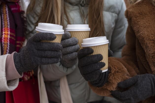 温暖的衣服把拿咖啡杯的手收起来女人都市冬天