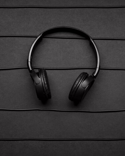 平面音乐与黑色耳机和电缆安排音乐元素艺术布局