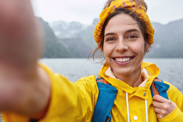 高兴快乐的女性有远征之旅 自拍肖像 在相机里伸出手 笑容灿烂女性休闲健康