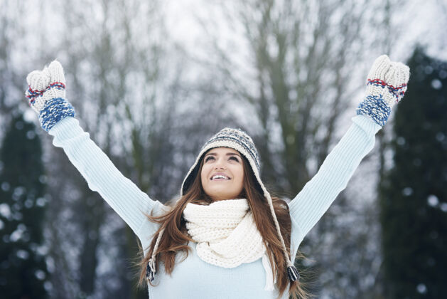 抱着年轻女子享受冬天的空气手套手臂魅力