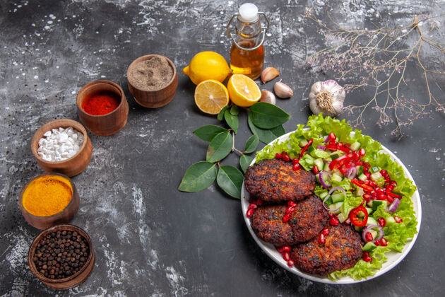 美味的肉片顶视图美味的肉排与蔬菜沙拉在灰色地板上的照片食物餐菜一餐菜晚餐