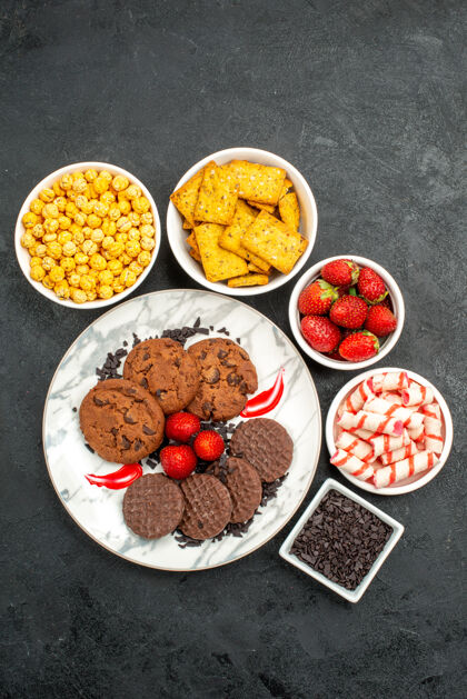 饼干俯瞰美味巧克力饼干与不同的零食在黑暗的背景茶甜饼干宴会水果饮食