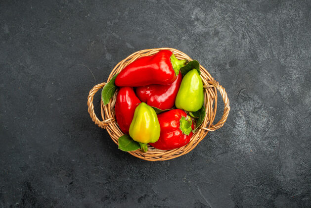 素食顶视图胡椒篮与红色和绿色类型在黑暗的背景与自由空间胡椒篮子番茄萝卜