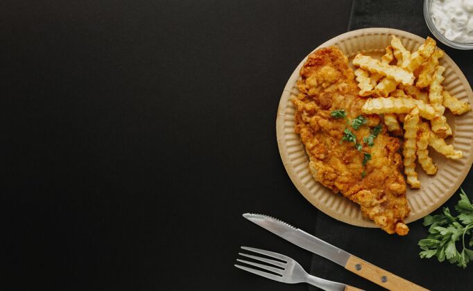 油炸盘子上的鱼和薯条的顶视图 带有餐具和复印空间食物菜空间