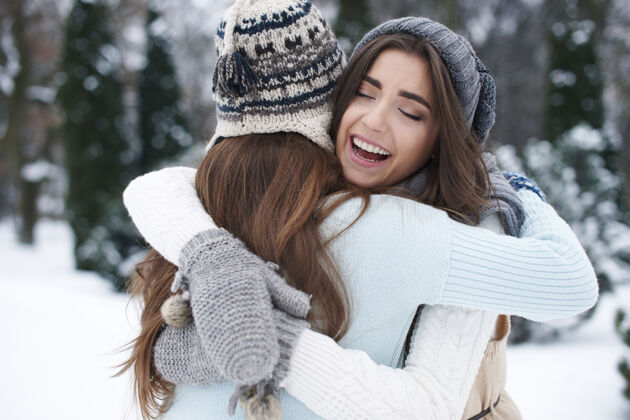 手臂环绕最好的朋友的冬天拥抱结合人自然