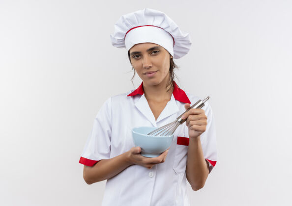 厨师年轻的女厨师穿着厨师制服 拿着搅拌器和碗 站在隔离的白色墙壁上 留有复印空间碗厨师年轻
