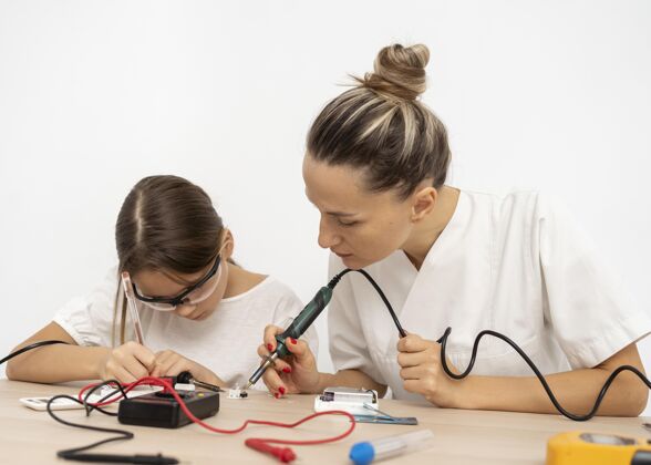 教育女孩和女老师在做科学实验安全眼镜学习学校