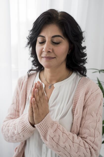宗教闭着眼睛祈祷的女人的前视图崇拜女性祈祷