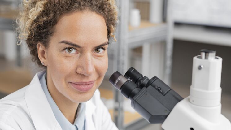 研究笑笑女研究员在实验室用显微镜女人生物化学生物学