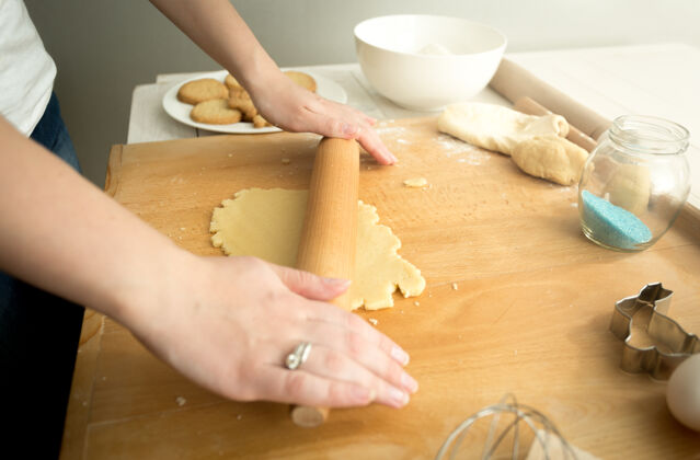 食物准备调特写照片的妇女正在做饼干面团在木板上比萨饼调子揉捏