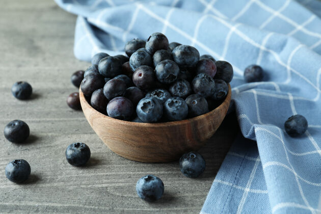 越橘一碗新鲜的蓝莓放在灰色的盘子里成熟水果蓝莓